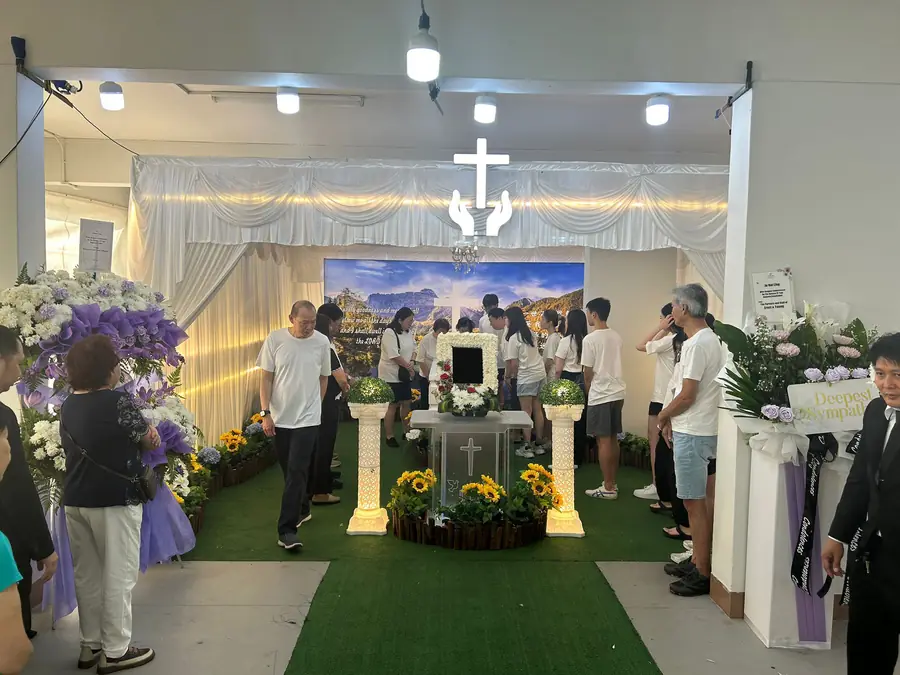 Family paying final respects at roman catholic funeral altar