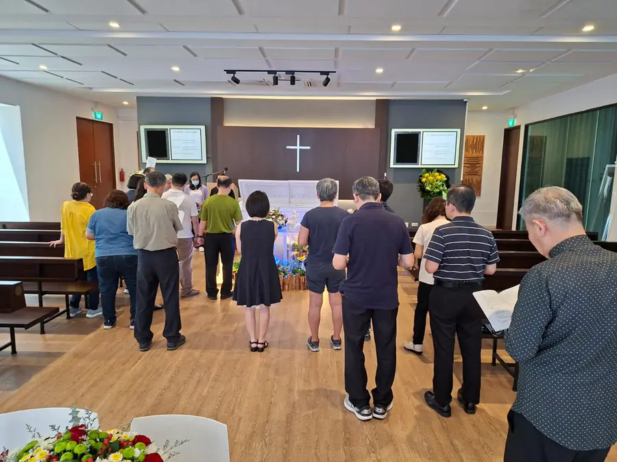 Family standing for roman catholic funeral prayer service