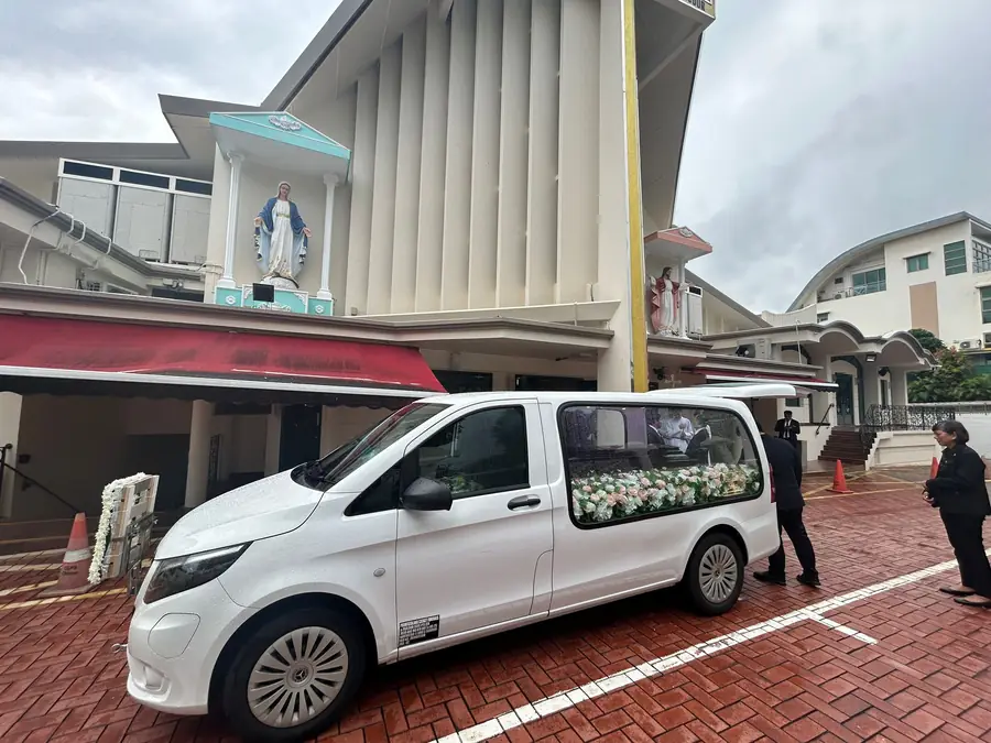Roman catholic funeral hearse arriving at church