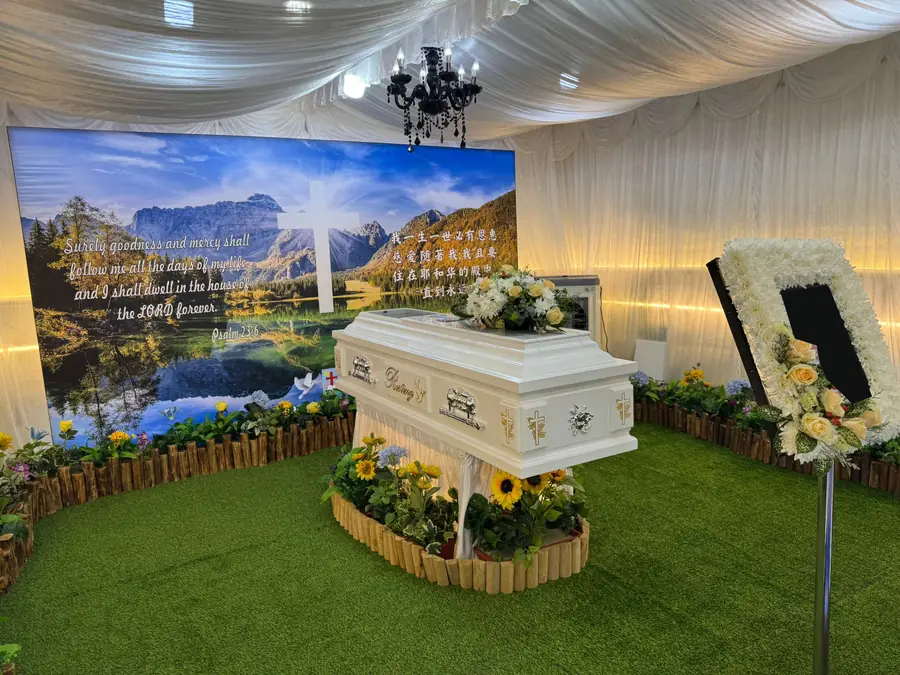 Roman catholic funeral white casket with floral arrangement