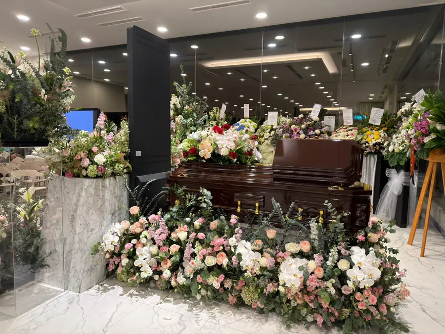 Freethinker funeral casket with floral arrangements