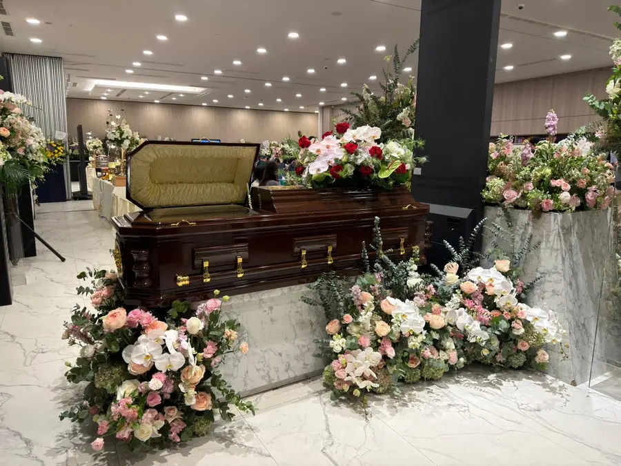 Freethinker funeral open casket with floral arrangements