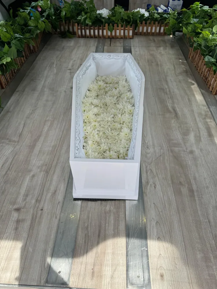 White infant casket lined with white flowers