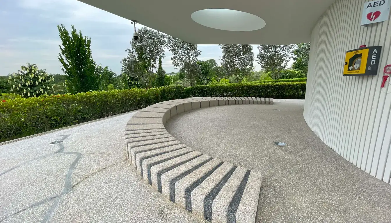 Covered seating area with curved bench and AED station at Garden of Peace